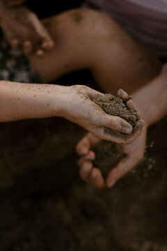 close up of young couple having fun on the beach and touching sand