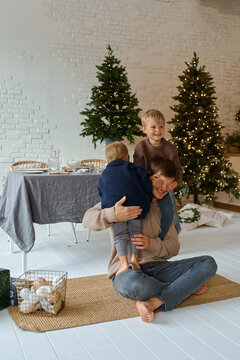 father and his children at home Christmas tree ornaments time together
