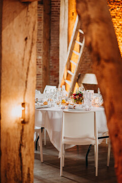 Beautiful table set indoors for reception with mood lighting in historic building