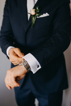 Man in suit adjusting watch and shirt