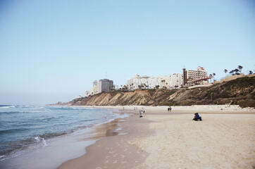 Israel, Netanya: Scenic view of the beach with people and  cityscape on the hill 