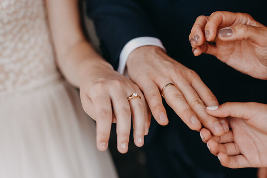 Bride and groom showing off wedding rings