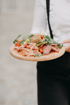 Waiter serving tapas on a wooden server