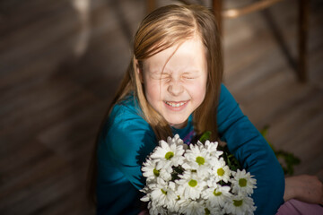 girl with blonde hair with white chrysanthemum flowers, selective focus
