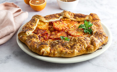 Red blood orange galette, seasonal pie with citrus. Tasty baking with honey and mint.