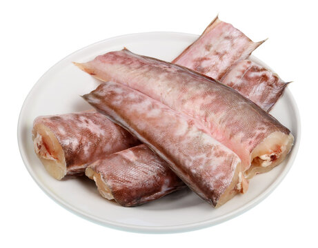 Pieces of frozen black congrio fish lying on a  plate  isolated