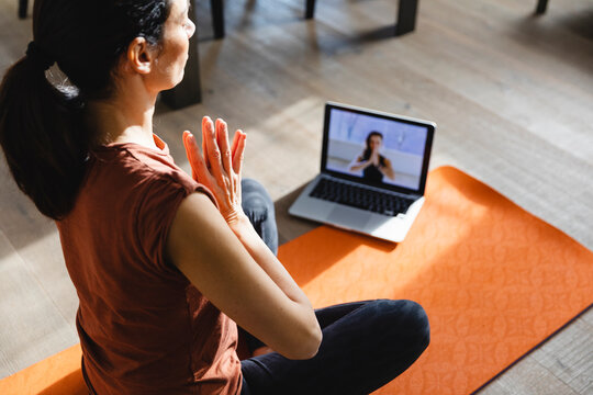 Woman taking an online yoga class at home