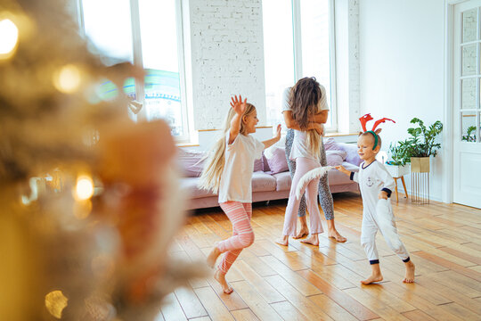 Happy children and mother having fun at home before Christmas