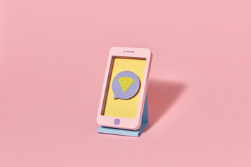 Craft smartphone from paper on a stand with wifi icon.