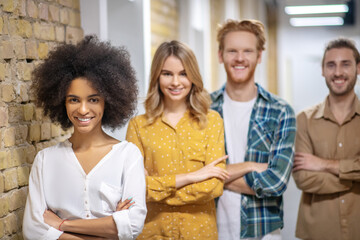 Group of young people standing with crossed arms and smiling