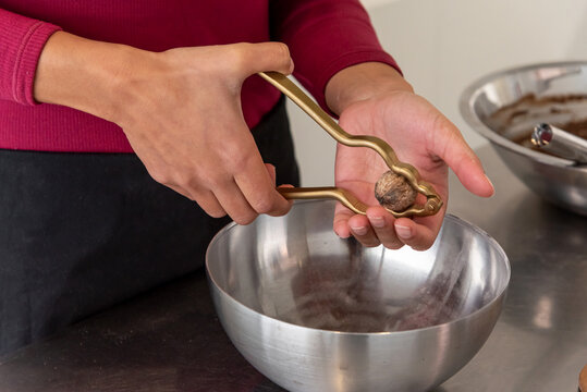 Hand using a nutcracker to crack a nut