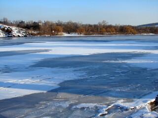 Landscape of the water surface of the wide Dnieper bound by an ice shell and covered with a fluffy blanket of snow.