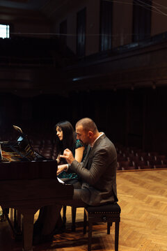 Man and woman, playing a piano