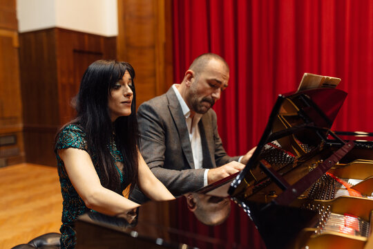 Man and woman, playing a piano