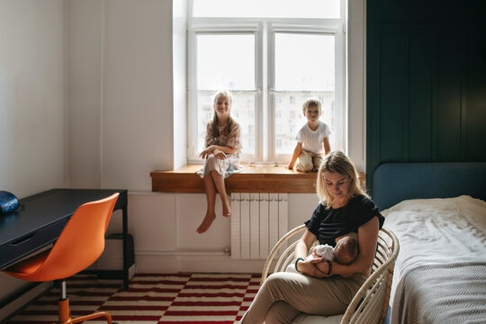 Beautiful family with small children in a cozy modern interior.