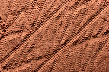Tyre pattern on the reddish-orange sandy surface. Imitation of the traces of the rover on the planet Mars. Top view