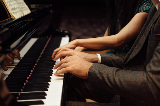 Man and woman, playing a piano