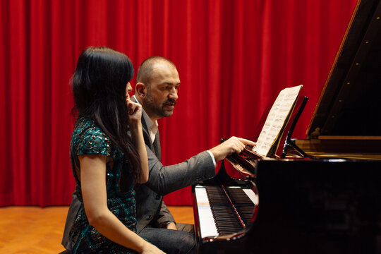 Man and woman, playing a piano
