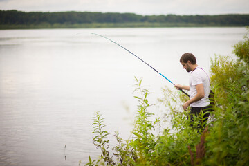 a man catches fish on the river, selective focus