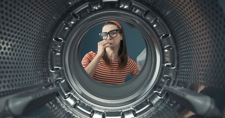 Woman looking into her smelly washing machine
