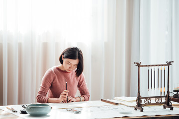 Asian woman writing calligraphy