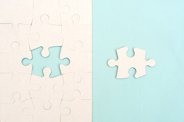 White puzzle on a blue background top view.