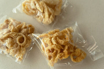 Pork crackle in package plastic bag on organic paper background with natural light