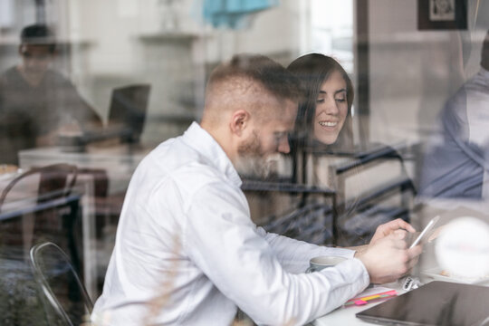 Business: Looking Through Window At Couple Reading Funny Text