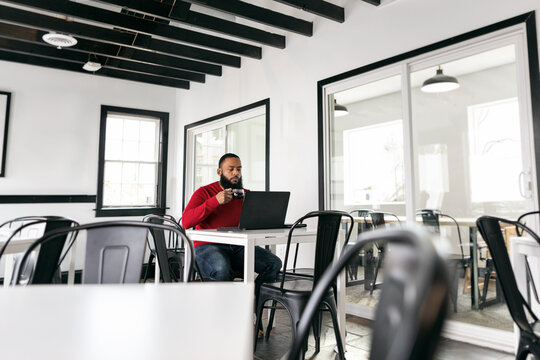 Business: Man Working Remotely Alone In Coffee Shop