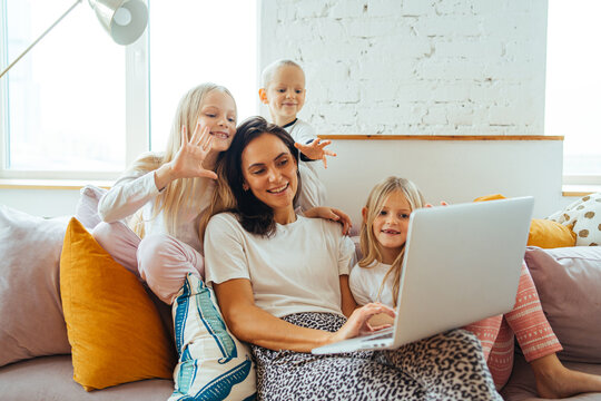 adorable mom and her young children make a video call with loved ones