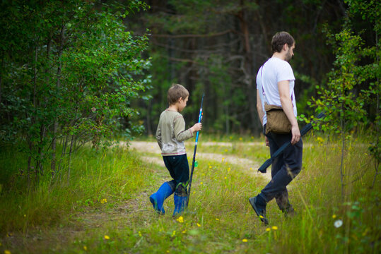 children with their father walking along a forest road, selective focus
