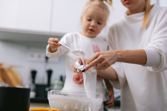 Little child helping her parent baking pastry