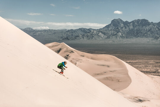 boy skiing down a sand dune