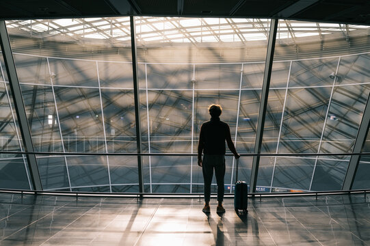 Anonymous traveler standing near window in airport