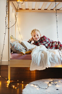 Toddler in Christmas pajamas laughing at camera