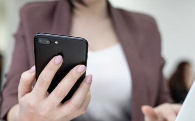 Female office worker typing on the phone, working at home office hand on keyboard close up. High quality photo