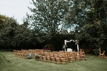 Beautiful outdoor wedding ceremony set up with wooden folding chairs