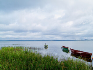 boats near the shore on the calm water of the lake   