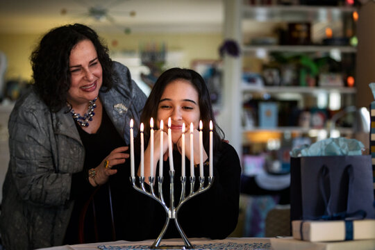 Hanukkah: Girl And Mother Admire Lit Candles