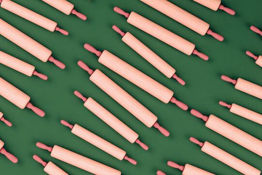 Pink rolling pins on green background