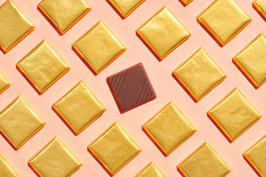 Piece of chocolate amidst desserts in golden foil