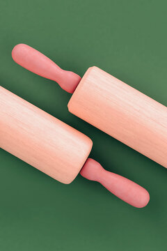 Pink rolling pins on green background