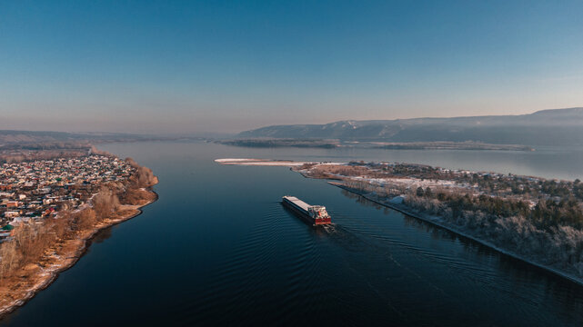 Aerial view of a cargo ship passing the narrow canal