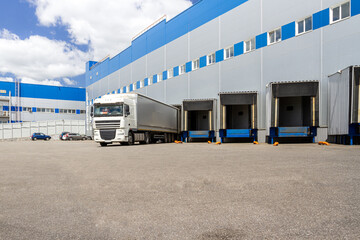 Truck while loading in a big distribution warehouse with gates for for loading goods and trucks