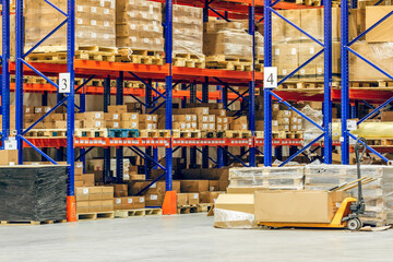 Interior of a modern warehouse storage of retail shop with pallet truck near shelves
