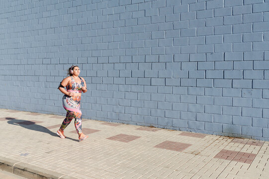 Full-figured woman running to music