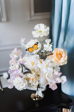a still life of a bunch of flowers on the piano with butterflies on it