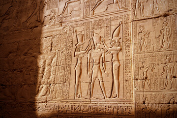 Hieroglyphic carvings on the exterior walls of an ancient egyptian temple