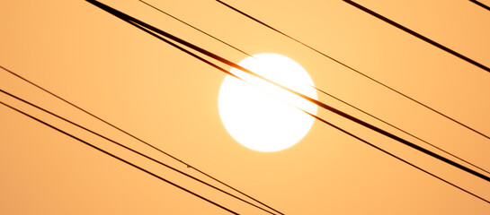 Electric cable on sunrise background, hot heat energy on silhouette golden sky wallpaper, clear...