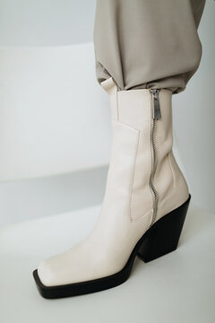 Stylish boot stepping on chair